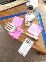 Photo showing sterling silver fork, candle holder, and weighted salt shaker with sticky notes describing each item.