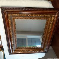 Image showing the antique wooden mirror frame with intricate carvings and replaced mirror glass with size approximately 26 x 31 inches.