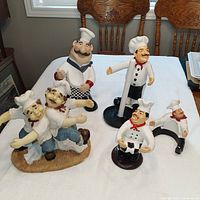 Photo of one large fat chef paper towel holder and four smaller chef-themed bottle holder figurines in varied sizes and poses.
