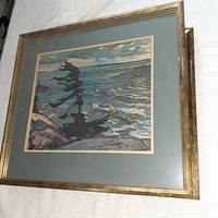 Framed art print of coastal seascape with windswept tree against ocean waves.