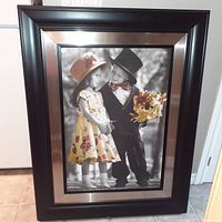 Framed photo depicting two children dressed in vintage style clothing with selective color
