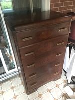 Front view of the tall chest of drawers showing five drawers with horizontal metal handles and dark wood finish.