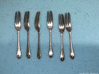 Six silver and silver-plated forks with detailed handle designs