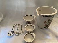 Photo showing entire set of ceramic measuring items including large pitcher, three nested measuring cups, and four measuring spoons with Portmeirion Botanic Garden floral pattern.