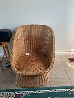 Front view of wicker chair showing woven seat and rounded backrest