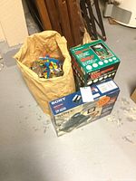 Overall photo showing a brown paper bag with coin wrappers inside, RadioShack coin sorter bank box, and Sony phone with answering machine box on the floor.