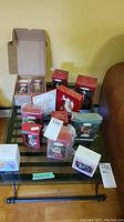 Top view of multiple boxed Hallmark Christmas ornaments arranged on a table, including opened box — overall lot overview.