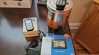 Garmin Nuvi 205 GPS unit box, Nokia phone on its box, Motorola phone on a container