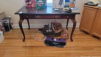 Front view of the wood sofa table showing drawer and decorative hardware, items on the table and floor below not included.