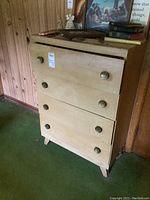 Full view of vintage wooden dresser with four drawers, original knobs, and angled legs, top laminate replaced