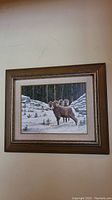 Full view of framed painting showing brown wood frame and visible textured cream matting around the artwork depicting Rocky Mountain Rams in snow.