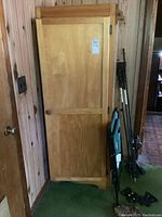 Front view of rustic wooden wardrobe cabinet with single door and round wooden knob.