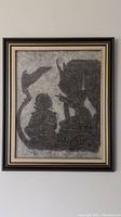 Frontal view of the framed charcoal rubbing artwork showing the two figures and temple background.