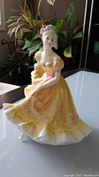 Full view of the Royal Doulton Ninette figurine showing the yellow dress and posture