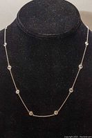 Full view of necklace draped on black display showing chain and CZ stations evenly spaced