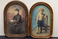 Two oval framed hand tinted photographs with convex glass, showing a woman and a boy