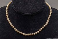 Full front view of the pearl necklace on display stand.