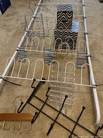 Full view of the white metal over-the-door shoe organizer with holding compartments, with all accessory items included placed on top or around it.
