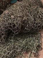 Close-up image of the large coarsely woven decorative nautical net showing dark brown color and texture.