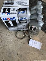 Photo showing box and 5 bottles of Mobil 1 5W-20 synthetic motor oil with oil wrench