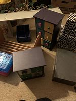 Overview of the wooden desktop caddy, wooden storage boxes shaped like houses, plastic storage boxes, and metal container.