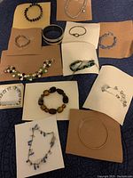 Overview of all 13 bracelets arranged on paper backgrounds showing variety of styles and colors