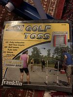 Box cover showing Franklin Golf Toss ladderball game with two collapsible ladder targets and game players outdoors.
