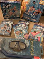 Photo of all items in original sealed packaging including Emperors Lounge, inflatable mat, floating chair, swim rings, baby care seat, snorkel set.