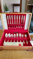 Full view of the Original Rogers silverplate cutlery set in a wooden case with red felt lining, showing knives, forks, and spoons arranged in slots.