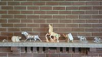Wide shot of all seven animal figures arranged on a mantel, showing varying sizes and materials.