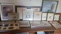 Photo capturing full selection of framed prints arranged on table showing diverse styles and frame types