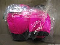 Bloch warm up booties in pink and black colors, sealed in original plastic packaging.