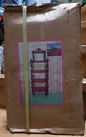 Box front showing image of assembled wooden 5-tier bakers rack display shelf with beveled shelving and decorative spindles.