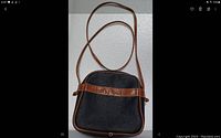 Front view of black Esprit purse with brown trim and embossed horizontal strap.