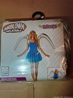 Front of original packaging showing Airblown Inflatable Wings costume with photo of model wearing wings and product branding