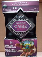 Front of box showing the MERGE Cube with hologram and bilingual text in English and French, highlighting the ability to hold virtual objects.