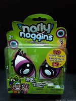 Narly Noggins 3D Pony Eyes helmet accessory pair in sealed packaging, brightly colored with pink and white, Series 2 markings visible.