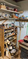 Shelving unit stocked with various boxes and containers of fasteners, tool parts, and supplies in a garage corner.