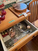 Photo of drawer with various metal cookie cutters, baking pans, and a glass oil or vinegar dispenser.