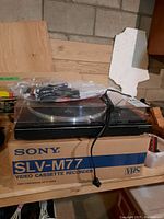 Pioneer PL-570 turntable on top of Sony VHS recorder box, cables attached, in a workshop setting