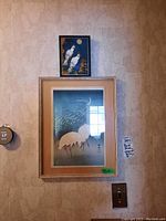 Frontal view of framed bird print with smaller artwork above, showing overall arrangement