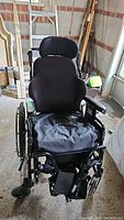 Front view of black custom ROHO wheelchair with padded seat and adjustable headrest.