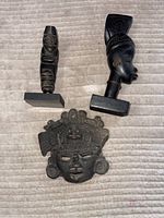 Lot showing all three carved statues together on a light beige surface