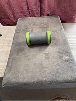 Memory foam gray velour dog bed with battery-operated rolling toy placed on top, showing size and condition of bed and toy.