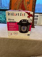 Front of unopened box showing Instant Pot Duo Nova 6 quart, multi-use cooker image and branding.