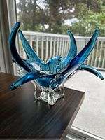 Front view of turquoise blue and clear chalet style glass sculpture showing multiple elongated spikes.
