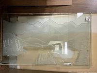 Full view of large rectangular etched glass panel depicting mountains, river, and pine trees.