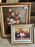 Photo showing both original framed floral oil paintings on canvas, larger behind smaller, with visible gold-toned wooden frames.