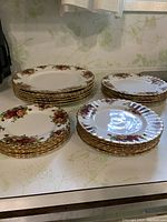 Four stacks of plates: largest stack of dinner plates, two medium stacks, one smaller stack