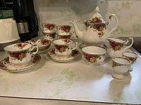 Overview of entire tea set including teapot, cups, saucers, creamer, sugar bowl and egg cups
